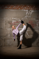 Beautiful hip hop girl dancing over grey brick wall