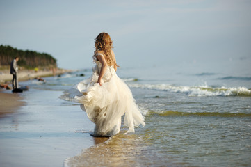 Fototapeta na wymiar Walking Bride wzdłuż wybrzeża morskiego