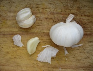 Garlic cloves on kitchen board - obrazy, fototapety, plakaty