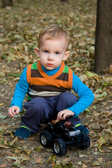 Little boy is playing with toy car