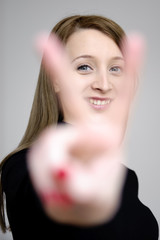 junge sympathische frau macht victory zeichen mit fingern