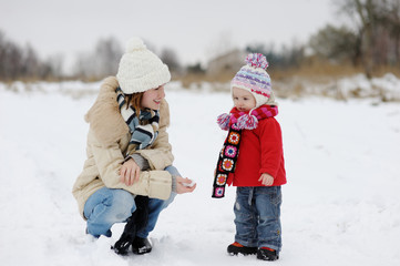 Little winter baby girl and her young mother