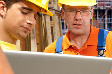 zwei Bauarbeiter mit Laptop