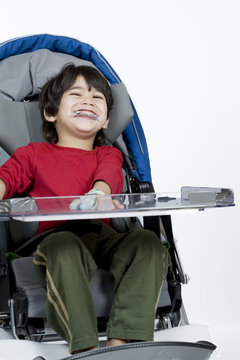 Three year old disabled boy in medical stroller