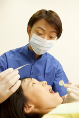 Obraz na płótnie Canvas 患者の女の子の治療をする歯科医男性