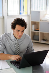 Homme assis devant un ordinateur portable