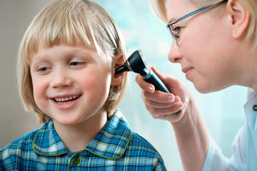 female doctor examining little child boy