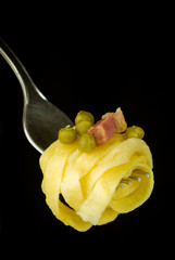 fork with noodles on black background
