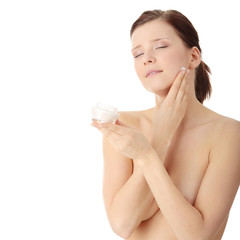 Woman applying moisturizer cream on face
