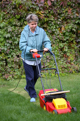 Middle Age Woman Mowing the Lawn