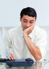 Bored young businessman at his desk