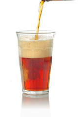 dark beer being poured in the tall glass