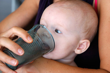 Bébé apprenant à boire au verre.