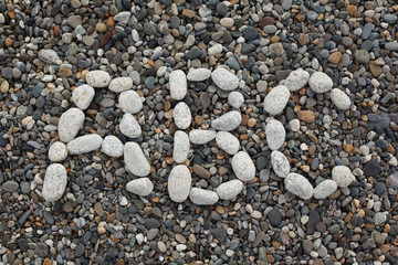 Beach, letters A, B, C combined from white stones on pebble