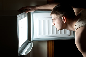 Hungry man opening fridge.