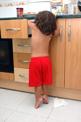 Niño abriendo cajones en la cocina