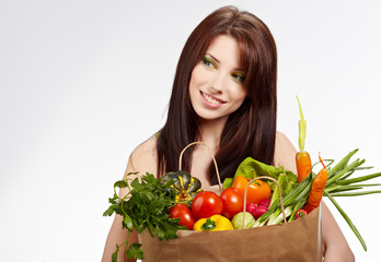 Smiling woman with fruits and vegetables. Over white background