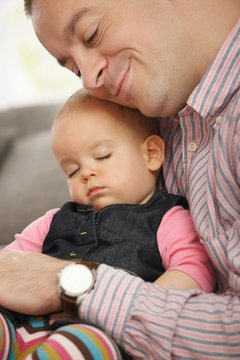 Baby sleeping in father's arm