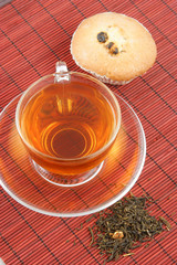 Cup of tea and fruitcake on bamboo background