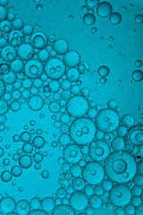 blue colored liquid with bubbles of oil