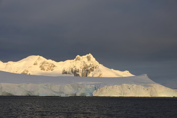 Snowcapped Land in Antarctica seen from a sailing boat