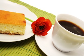 ein Stück Käsekuchen mit einer Tasse Kaffee