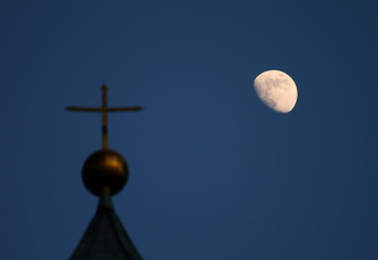 Fototapeta na wymiar Ein Kirchenkreuz und der Mond