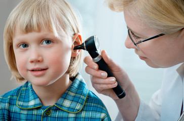 female doctor examining little child boy