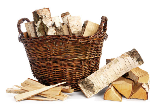birch firewood in a wicker basket and kindling