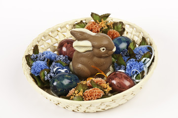 Schokoladenosterhase und Ostereier im Nest, isoliert auf weiß