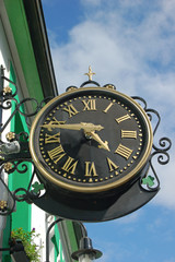 Fototapeta na wymiar The time on an irish clock with clover decorations