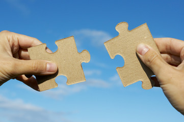 The hand holds puzzle on a background of the sky