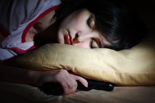 Women sleeps with the gun under the pillow