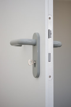 weiße offene Holztür mit Schlüssel