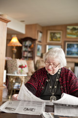 Fototapeta na wymiar 87 year old woman reading at home