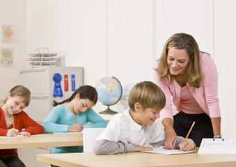 Fototapeta premium Teacher helping student in classroom