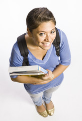 Student wearing backpack carrying books