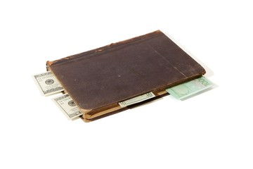Old book with banknote bookmarks isolated