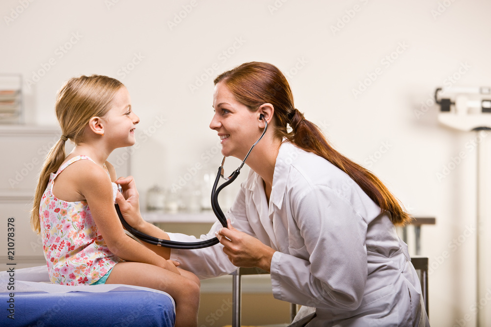 Wall mural doctor giving girl checkup in doctor office