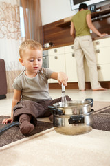 Little boy playing in kitchen