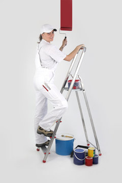 Femme peignant un mur à l'aide d'un rouleau