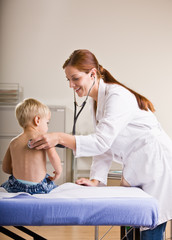 Doctor giving boy checkup in doctor office