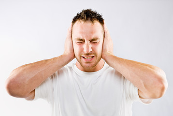 Man blocking out loud noise from ears