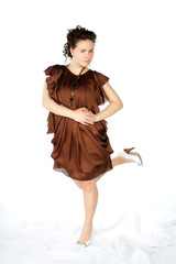 young atractive woman in brown dress hold one leg up