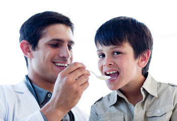 Assertive doctor giving medicine to a little boy