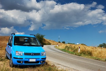 Obraz na płótnie Canvas Nowoczesne blado niebieski samochód przy drodze krajowej