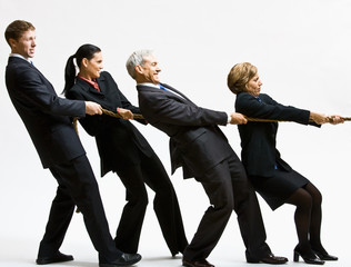 Business people playing tug-of-war