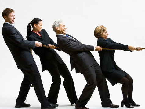 Business people playing tug-of-war