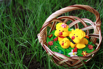 Saccharine chickens in a basket on a grass