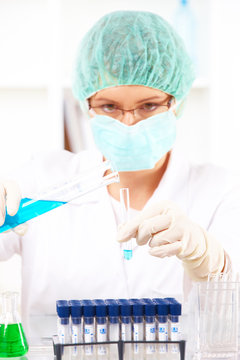 Female researcher holding up a test tube and retort